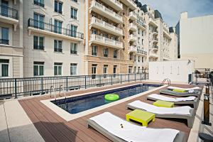 an apartment patio with a pool and lounge chairs at The Social Hub Paris La Défense in Puteaux