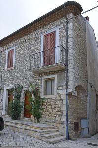 una casa in pietra con balcone sul lato di La Casa Di Zia Nina a Campolattaro