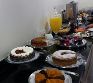 a table topped with cakes and desserts on plates at Imbau Palace Hotel in Imbau