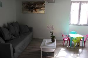sala de estar con sofá, mesa y sillas en Un petit coin de paradis, en Champigny-sur-Veude