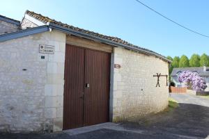 un edificio con una puerta marrón con un cartel. en Un petit coin de paradis, en Champigny-sur-Veude