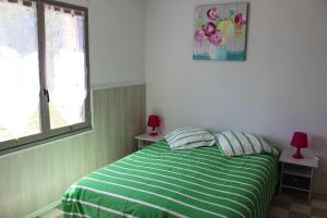 1 dormitorio con 1 cama verde y blanca con 2 lámparas en Un petit coin de paradis, en Champigny-sur-Veude