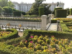 un parc avec des bancs et des fleurs devant un bâtiment dans l'établissement Luz Madrid Rooms, à Madrid