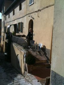 a woman sitting at a table outside of a building at La Macina in Cetona