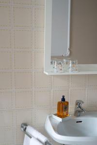 bagno con lavandino bianco e specchio di AMSEL VINTAGE Rooms a Vienna