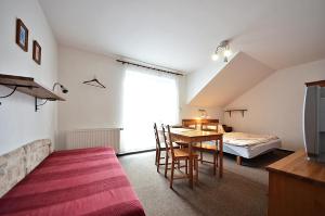 a room with a table and a bed and a bedroom at Pension Karin in Špindlerův Mlýn