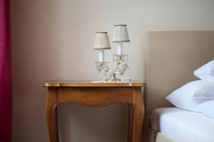 a table with two lamps on it next to a bed at AMSEL VINTAGE Rooms in Vienna