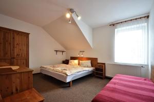 a small bedroom with a bed and a window at Pension Karin in Špindlerův Mlýn