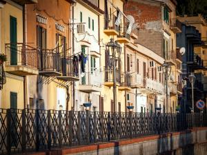 a row of buildings with balconies and a fence at Guest House a Portapalermo in Santo Stefano di Camastra