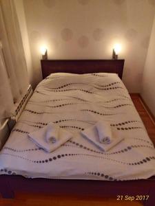 a bed with two towels and two pillows on it at Apartment Tifani in Belgrade