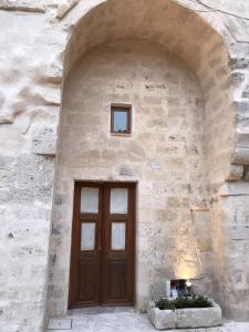 een stenen gebouw met een houten deur en een raam bij B&B Al Convento in Matera