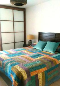 a bedroom with a bed with a colorful quilt on it at Cangas Plaza in Cangas de Onís