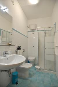a bathroom with a sink and a toilet and a shower at Liberty Guest House in Alghero