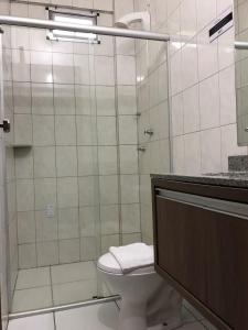 a bathroom with a toilet and a glass shower at Hotel Renata Criciuma in Criciúma