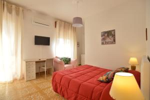 a bedroom with a red bed and a desk at Liberty Guest House in Alghero