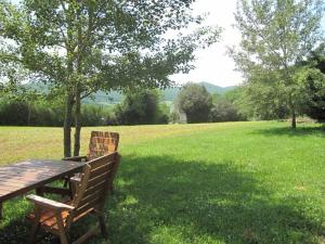 a wooden bench sitting in a field of grass at Chalet Des Menhirs in Moulin-Mage