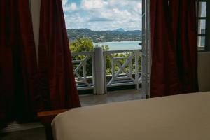 a bedroom with a view of the ocean from a window at Villa Thompson in Gros Islet