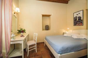 a small bedroom with a bed and a desk at Celestia Traditional Houses in Keramoto