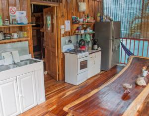 a kitchen with a stove and a refrigerator at J Bay : Burnt Toast Surfcamp in Nosara