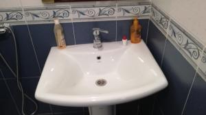 a white sink in a bathroom with bottles on it at Bri Apartment in Casablanca