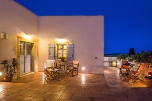 a patio with chairs and a table at night at Celestia Traditional Houses in Keramoto