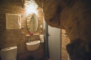 a bathroom with a sink and a toilet and a mirror at Celestia Traditional Houses in Keramoto