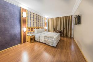 a bedroom with a bed and a dresser at Monumental Bittar Hotel in Brasília