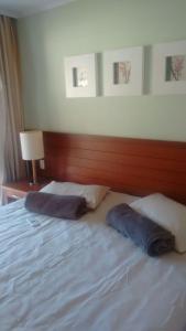 a bed with two pillows sitting on top of it at Flat particular no Resort em Angra Dos Reis in Angra dos Reis