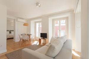 - un salon blanc avec un canapé blanc et une table dans l'établissement FLH Portas do Sol Cozy Flat, à Lisbonne