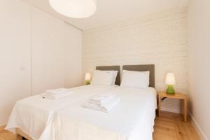 - une chambre avec un lit blanc et des draps blancs dans l'établissement FLH Portas do Sol Cozy Flat, à Lisbonne