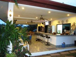 a restaurant with a bar with a bunch of chairs at D&K Smiley Phuket Resort in Rawai Beach