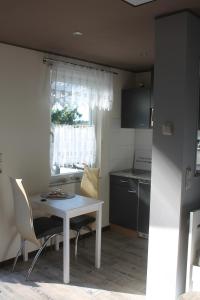 eine Küche mit einem weißen Tisch und Stühlen sowie einem Fenster in der Unterkunft Ferienhaus Kleine Hexe in Thale