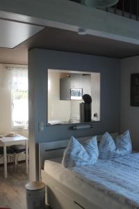 ein Schlafzimmer mit einer blauen Wand und einem Bett mit Kissen in der Unterkunft Ferienhaus Kleine Hexe in Thale