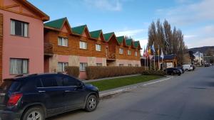 un coche azul estacionado frente a un edificio en Hotel Kapenke en El Calafate