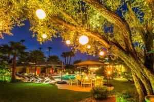 a resort with a pool at night at Desert Riviera Hotel in Palm Springs