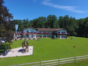 un gran patio con una casa y un parque infantil en Haus Waldesruh en Übersee