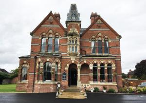 an old brick building with a tower at The Godwins in Hereford