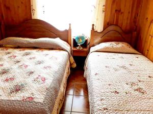 a bedroom with two beds and a window at Cabañas Rupu Lafquén in Pichilemu