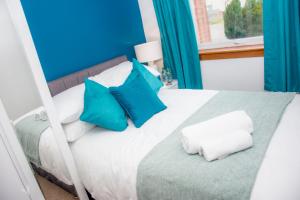 una camera da letto con un letto con cuscini blu e bianchi di Distillery Apartment 1 a Elgin