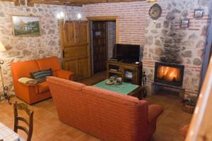 a living room with a couch and a fireplace at Casa La Plaza in Armuña