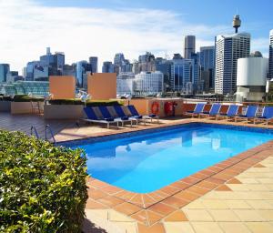 
a pool with a blue chair and a blue bench in front of it at Novotel Sydney Darling Harbour in Sydney
