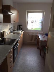 a kitchen with a sink and a window and a table at 3-Zimmer Ferienwohnung nähe Darmstadt in Roßdorf