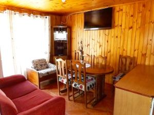 a kitchen with a table and chairs and a couch at Cabañas Rupu Lafquén in Pichilemu