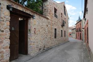 un callejón con un edificio de piedra con garaje en Casa La Plaza, en Armuña