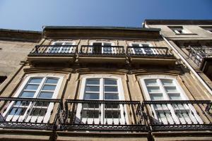 - un bâtiment avec des balcons sur le côté dans l'établissement Hostel Cross, à Lugo