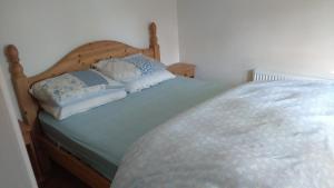 un letto con due cuscini sopra in una stanza di Cosy Lakeside Cottage John's hollow a Headford