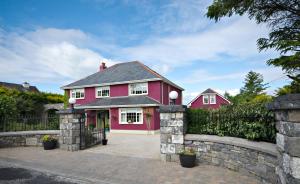 a pink house with a stone fence at Lurgan House in Westport