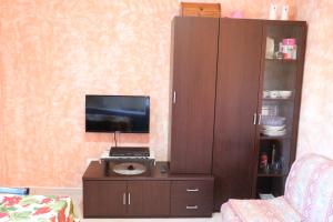 uma sala de estar com uma televisão e um armário castanho em Parcoverdepino em Bastia Umbra