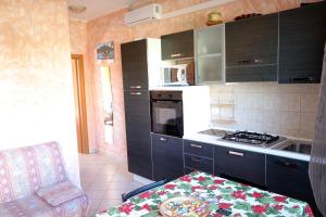 a kitchen with black cabinets and a stove top oven at Parcoverdepino in Bastia Umbra