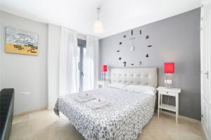 a bedroom with a bed, a dresser and a lamp at Apartamentos Salamanca in Málaga